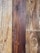 Natural wood planks with distinct grain patterns, showing variations in color from light tan to deep brown.
