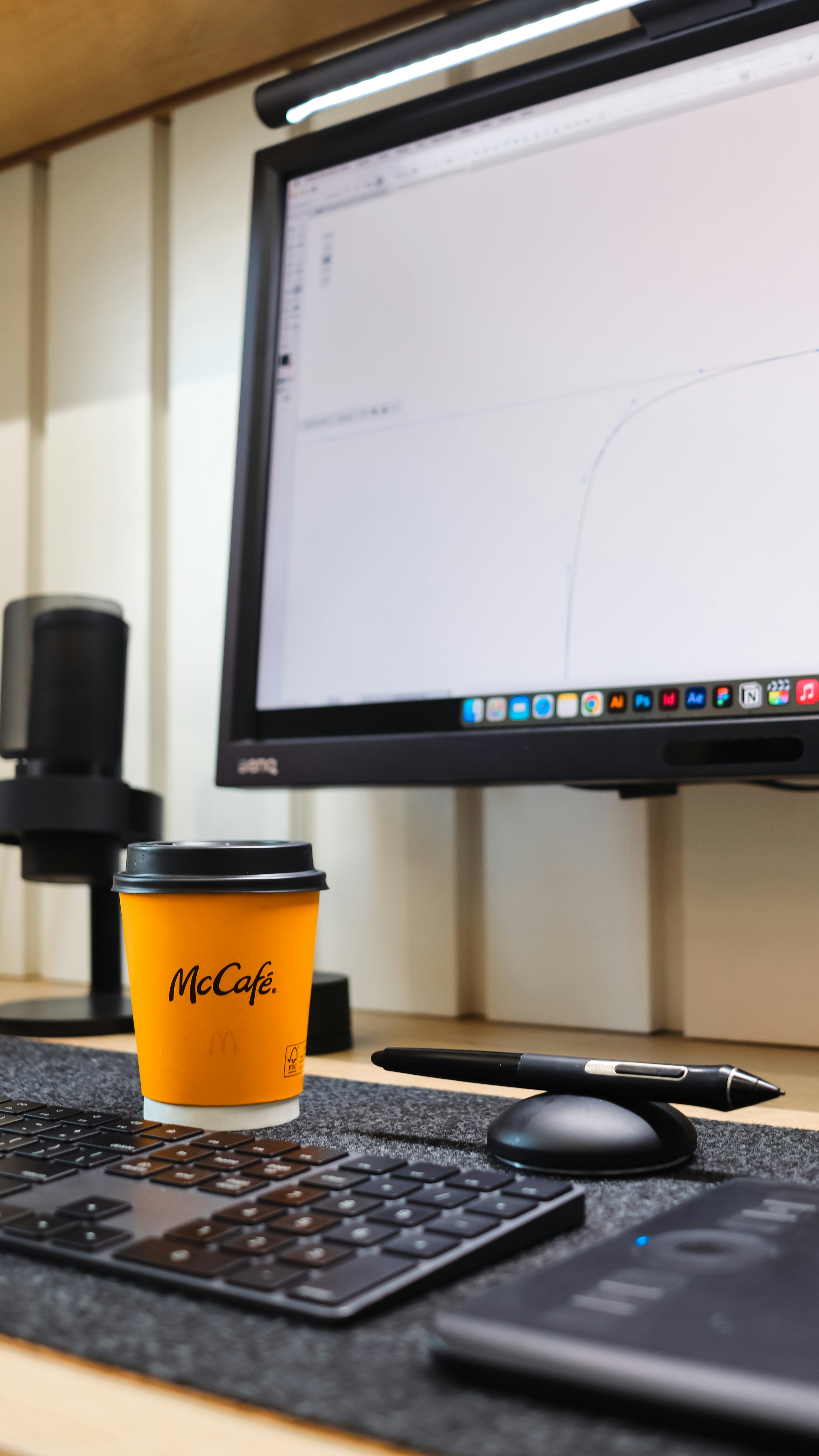 Professional design workstation with an orange coffee cup on a desk.