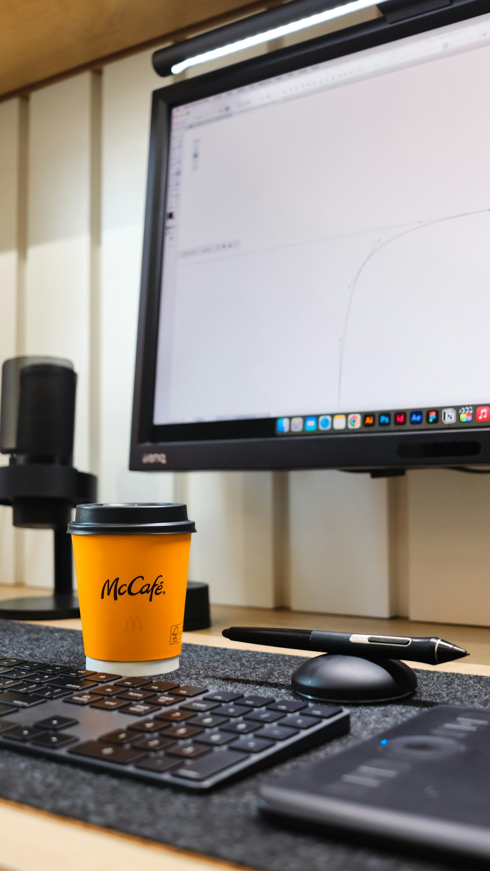 Eine Tasse Kaffee auf einem Schreibtisch neben einem Computermonitor