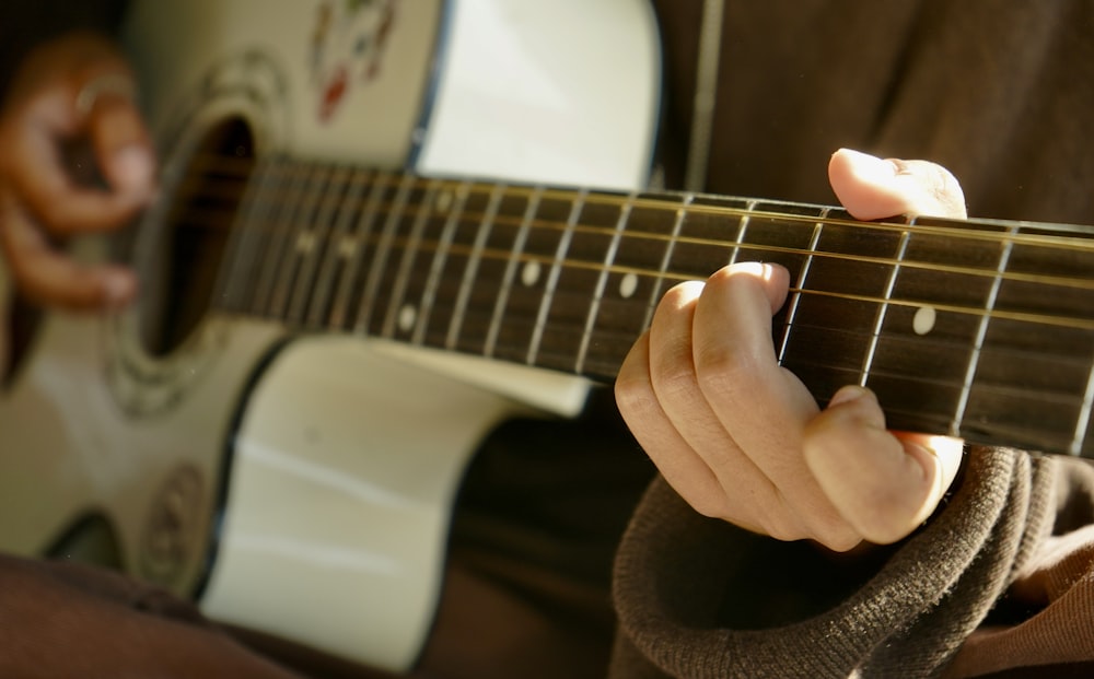 a person playing a guitar with their fingers