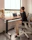 Photo of a man working at a stylish wooden desk surrounded by ergonomic furniture.