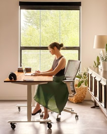 a woman sitting at a desk using a laptop computer