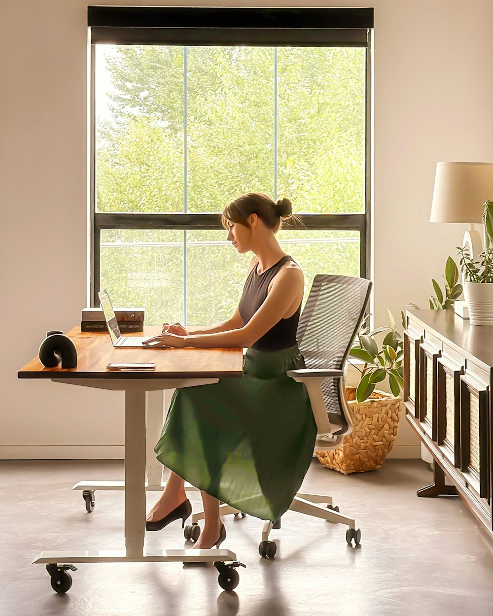 a woman sitting at a desk using a laptop computer