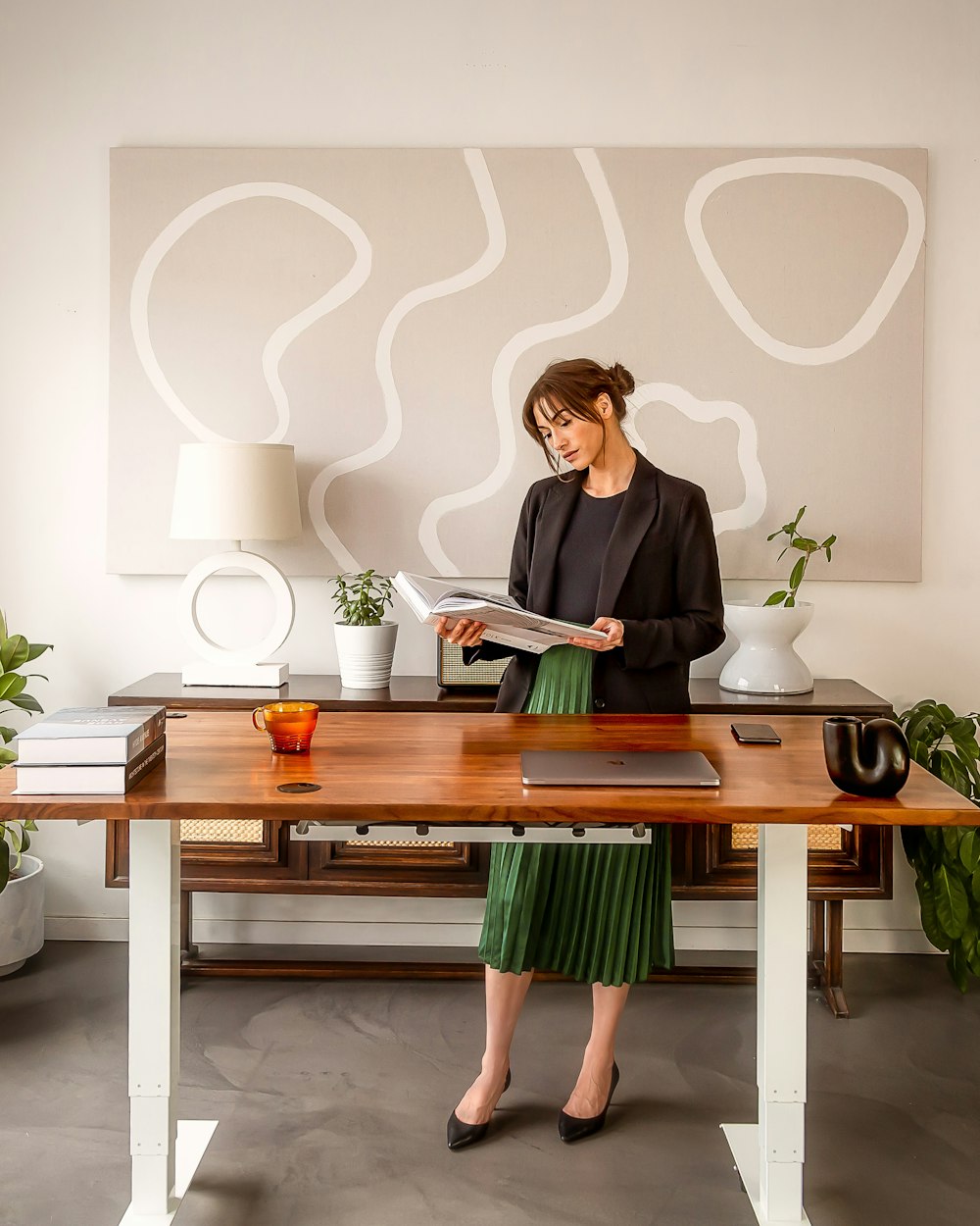 a woman standing at a desk reading a book