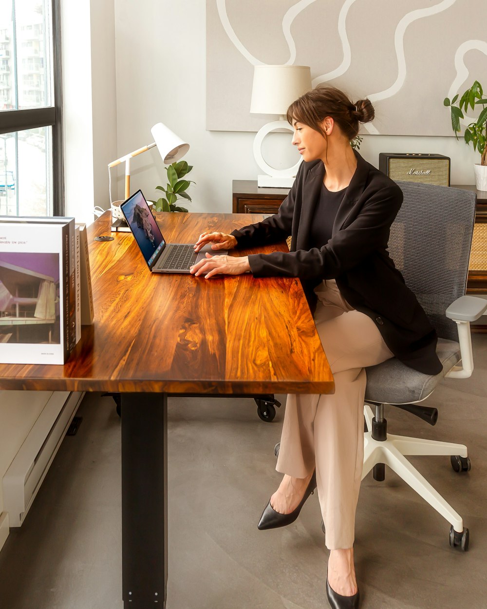 a woman sitting at a desk using a laptop computer