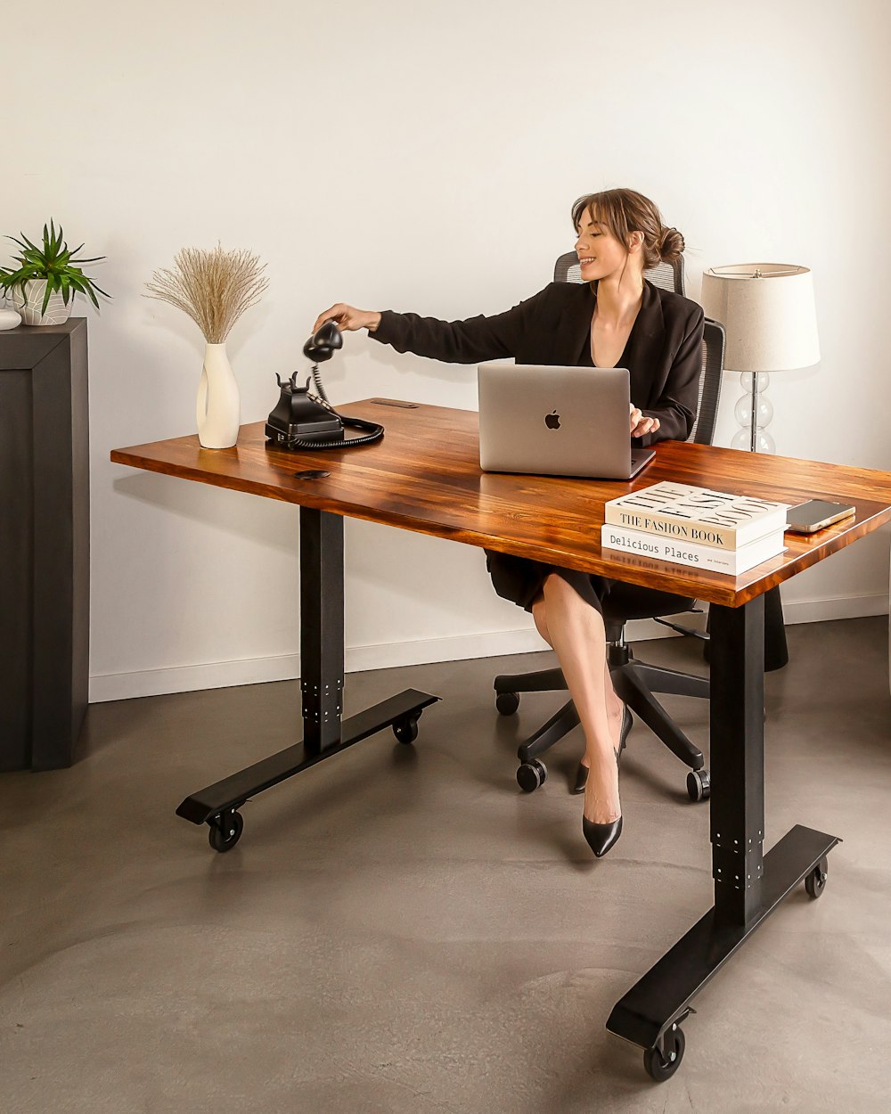 a woman sitting at a desk with a laptop