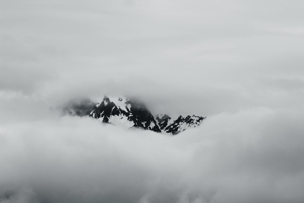 Une photo en noir et blanc d’une montagne couverte de nuages