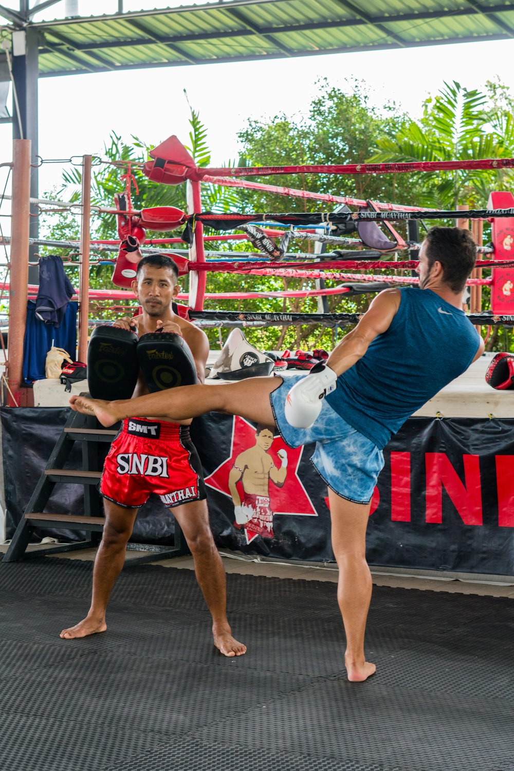 a man kicking another man with a kickbox