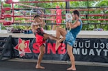 a couple of men standing next to each other in a boxing ring