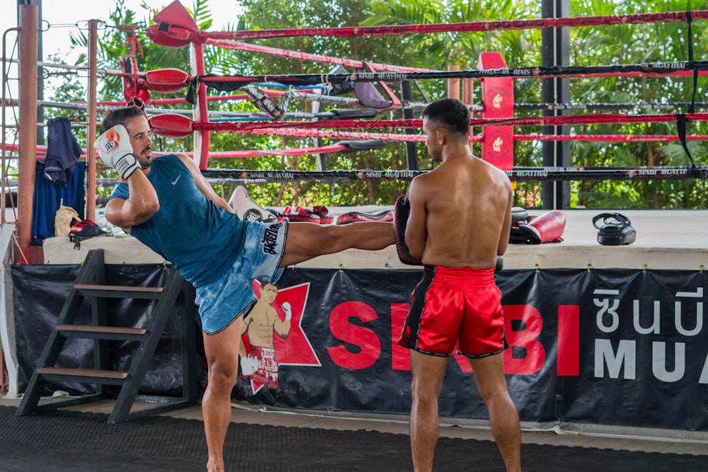 a couple of men standing next to each other in a boxing ring