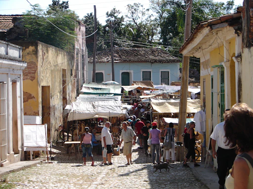 a group of people walking down a street next to buildings