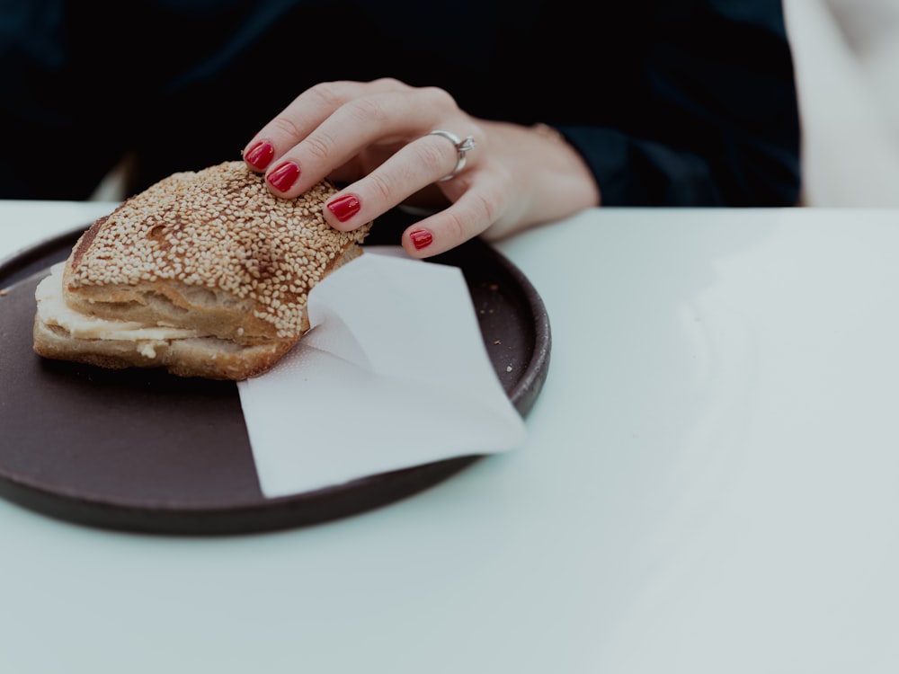 un primo piano di una persona seduta a un tavolo con un piatto di cibo