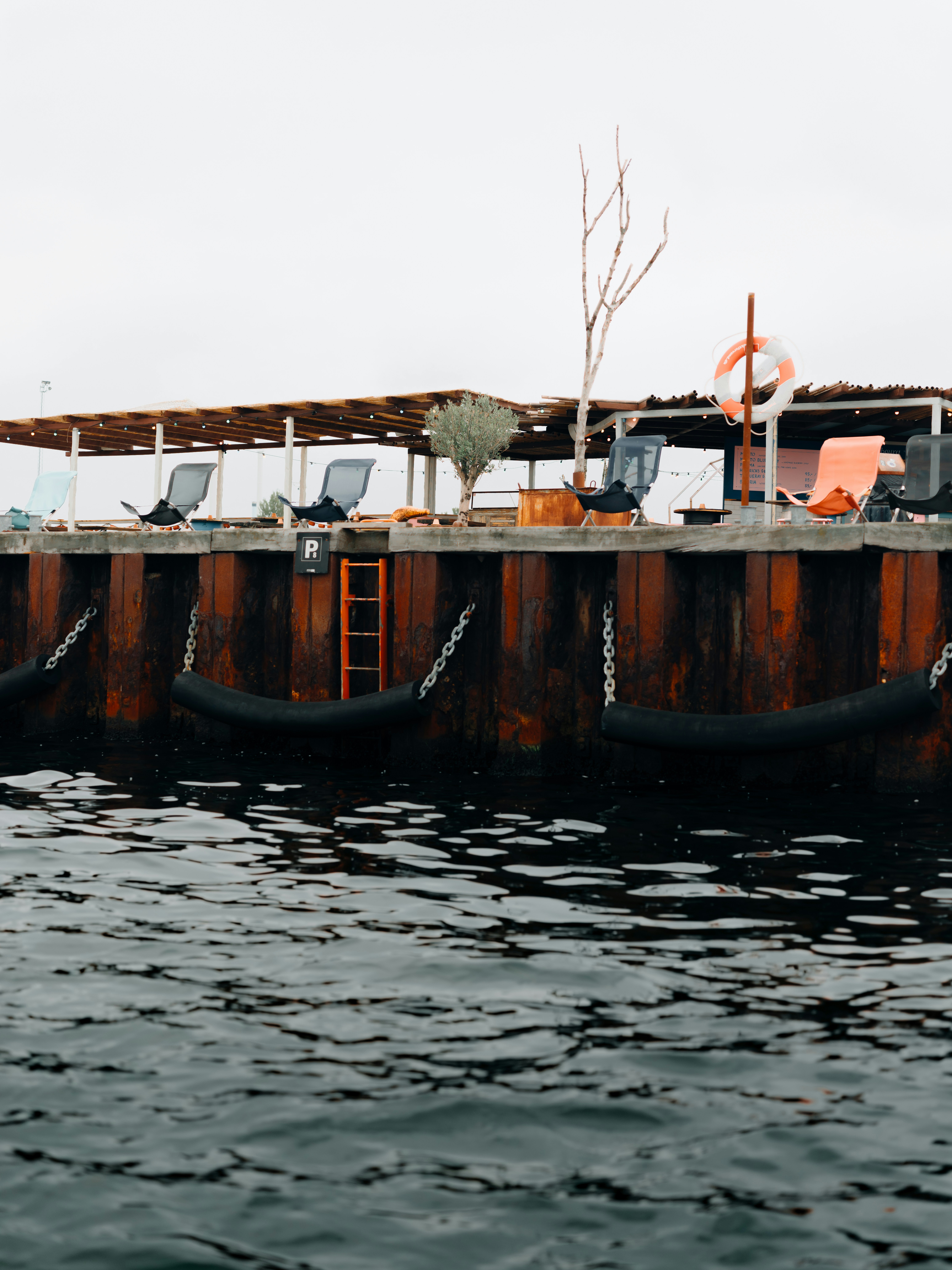 a row of chairs sitting on top of a pier