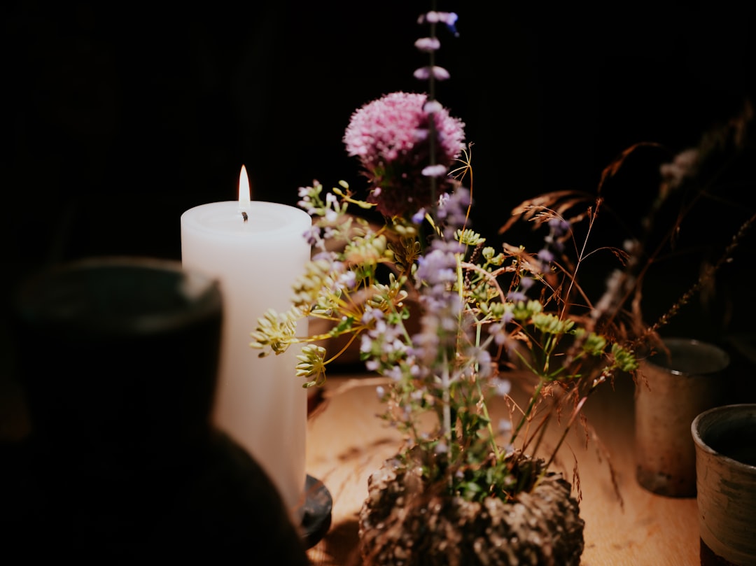 a candle and some flowers on a table,