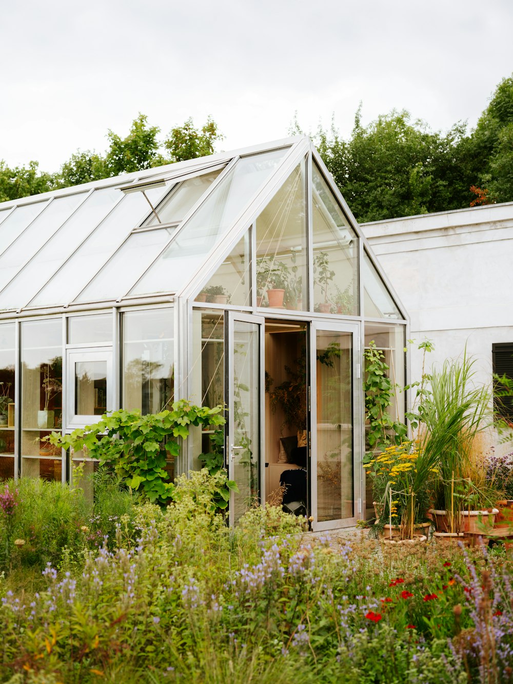 a house with a glass roof and a garden in front of it