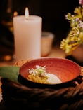 a bowl of food with a candle in the background