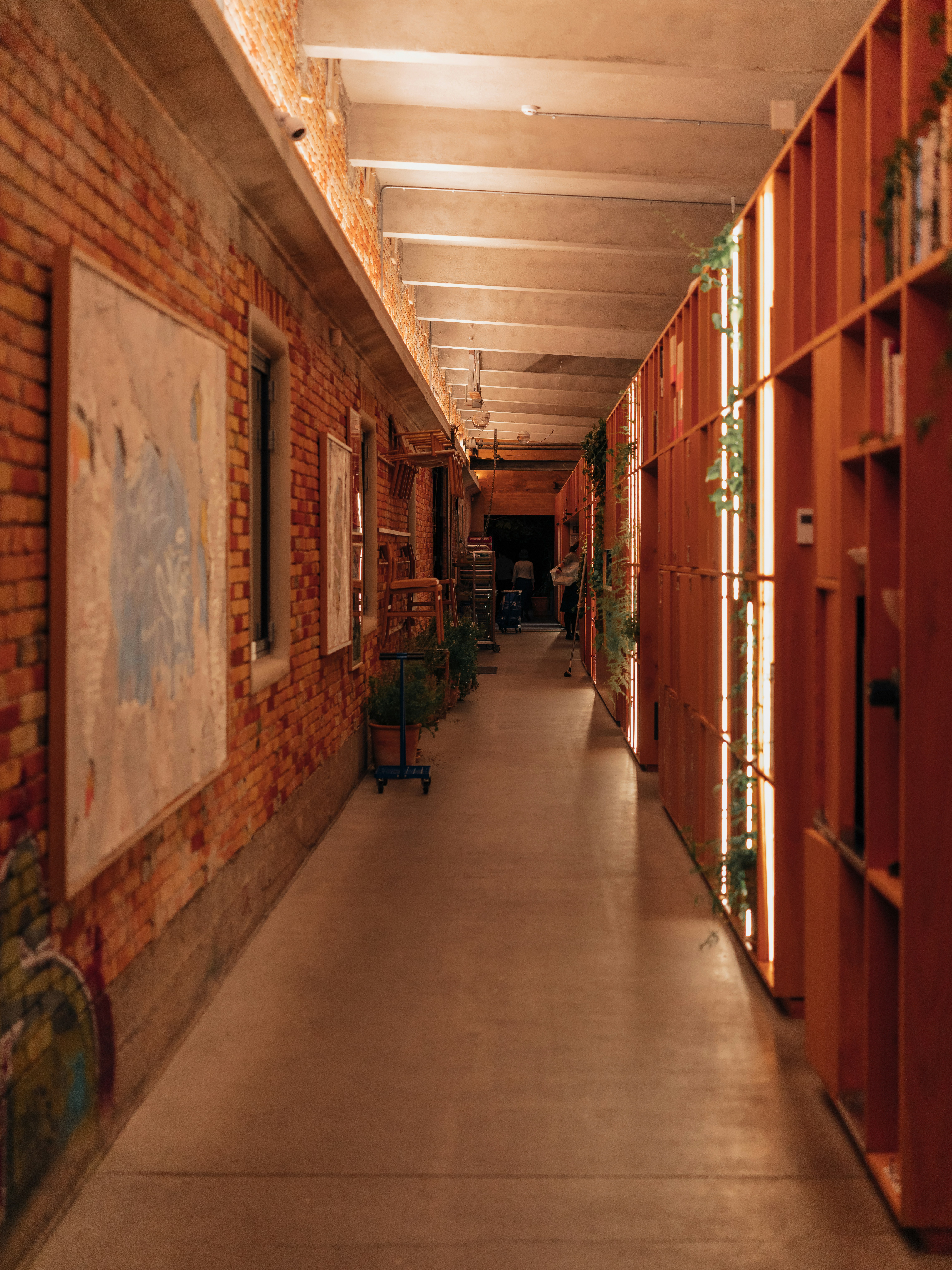 Warm shelter hallway with soft overhead lighting, clean and organised sleeping area, welcoming and safe environment