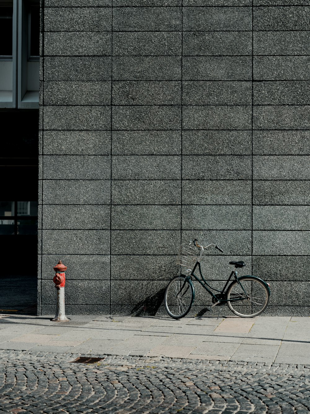 a bike parked next to a fire hydrant on a sidewalk