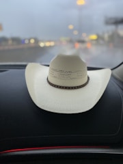 Close-up of a well-worn trucker’s cap resting on a dashboard.