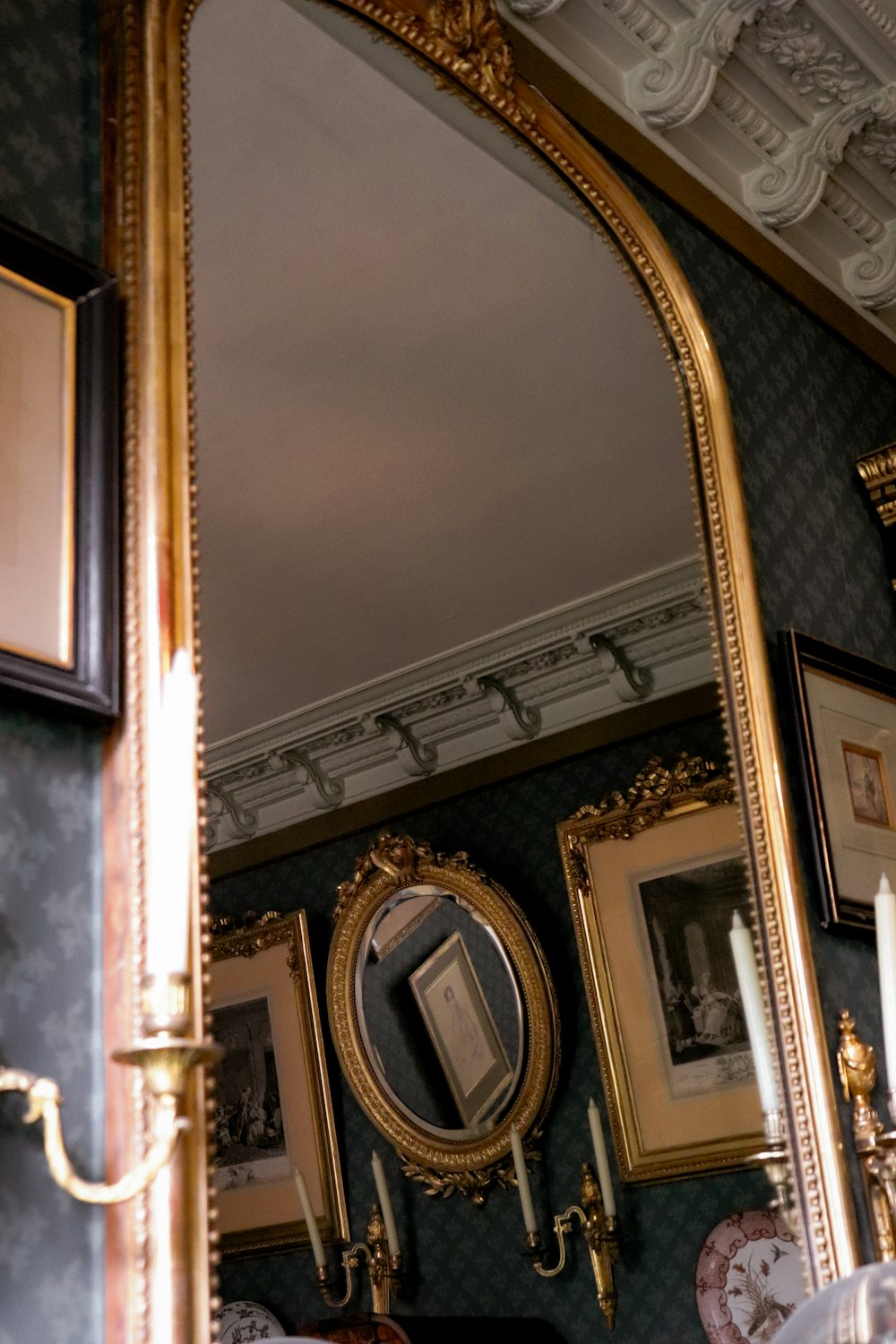 a large gold framed mirror sitting on top of a wall