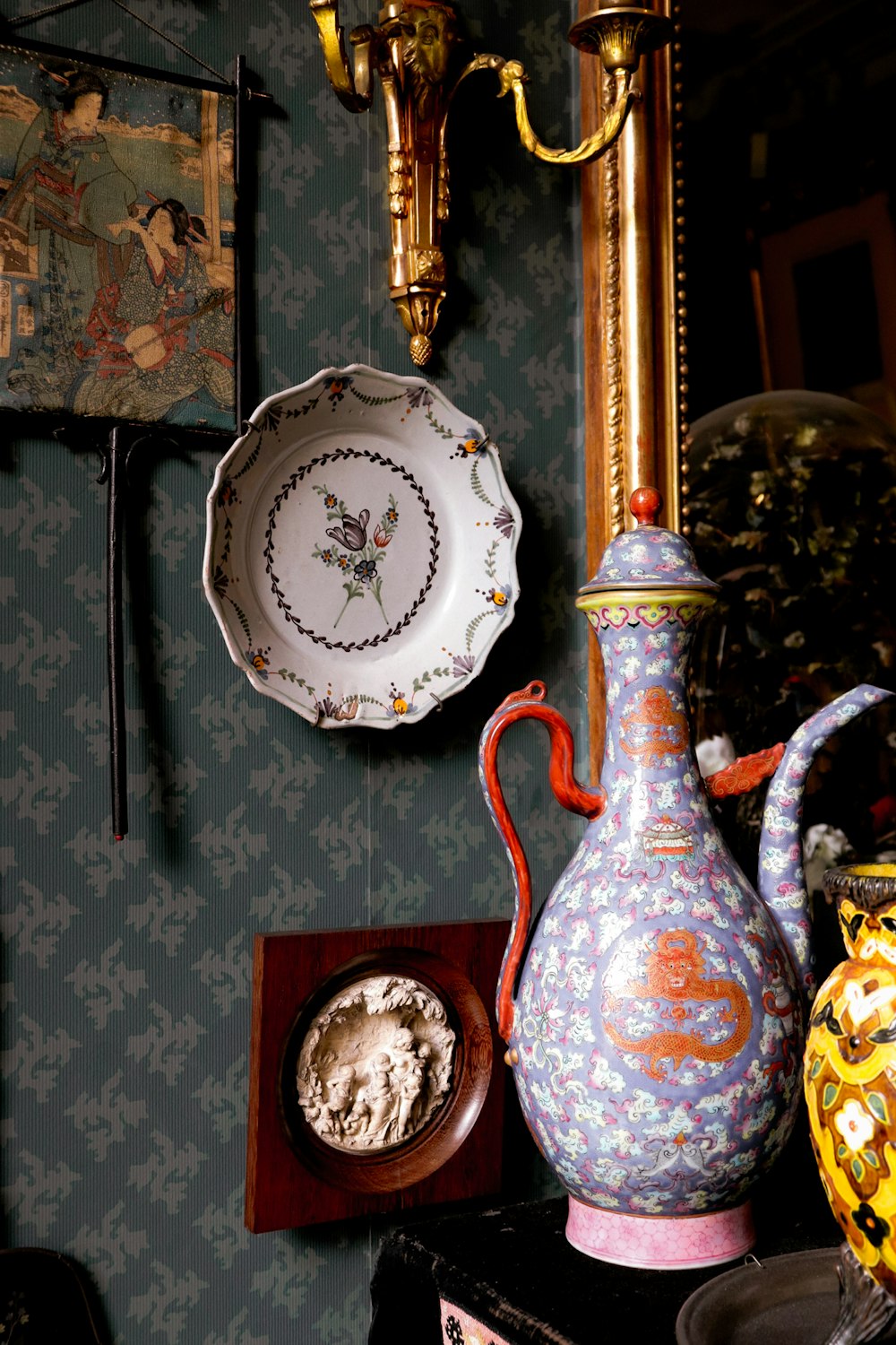 a blue wall with plates and vases on it