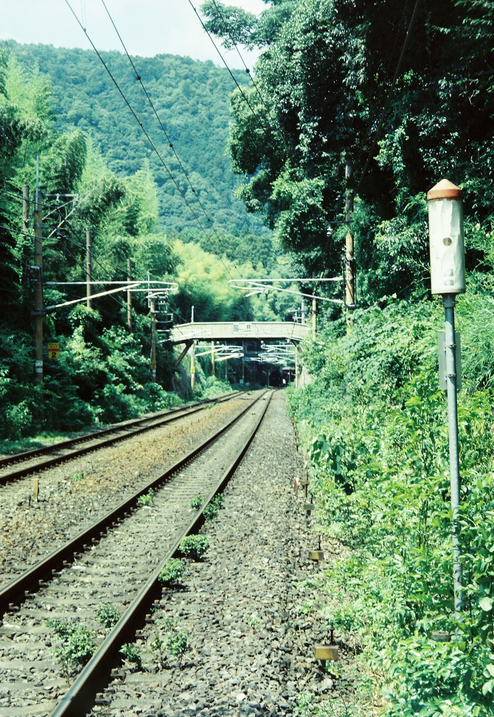 a view of a train track with a bridge in the background