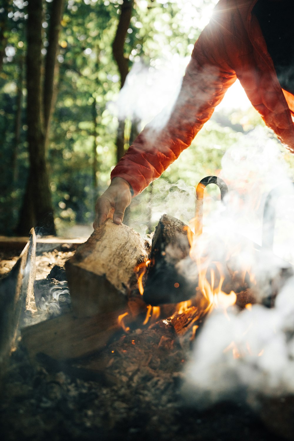 uma pessoa cozinhando comida sobre uma fogueira na floresta