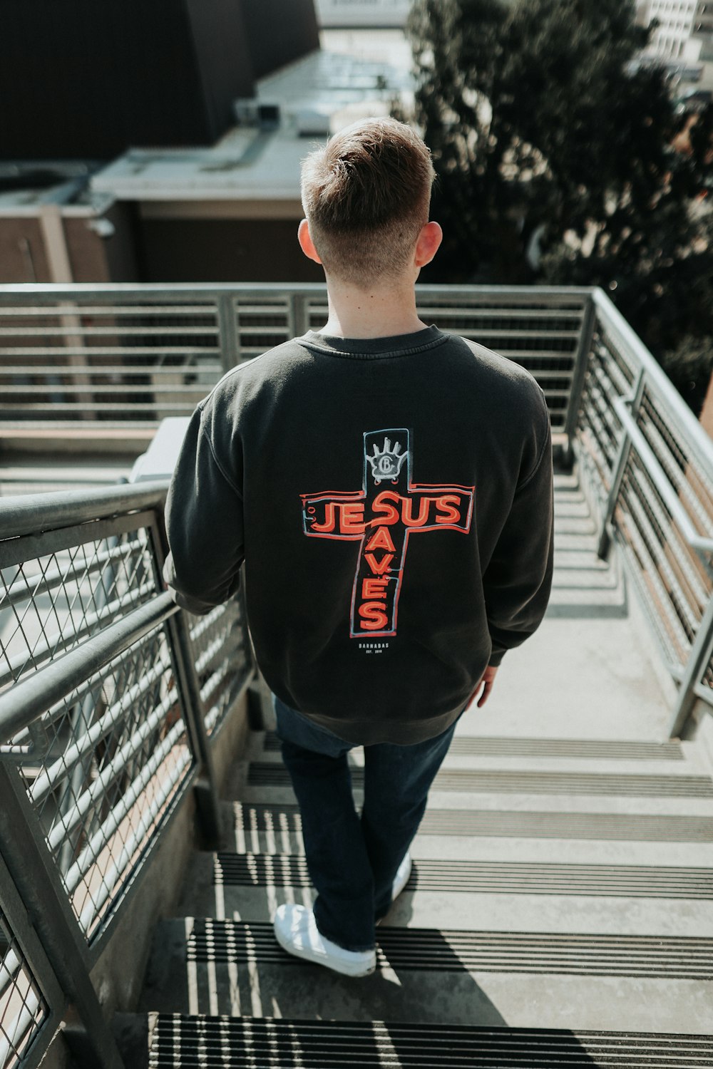 a man walking up some stairs with a cross on it