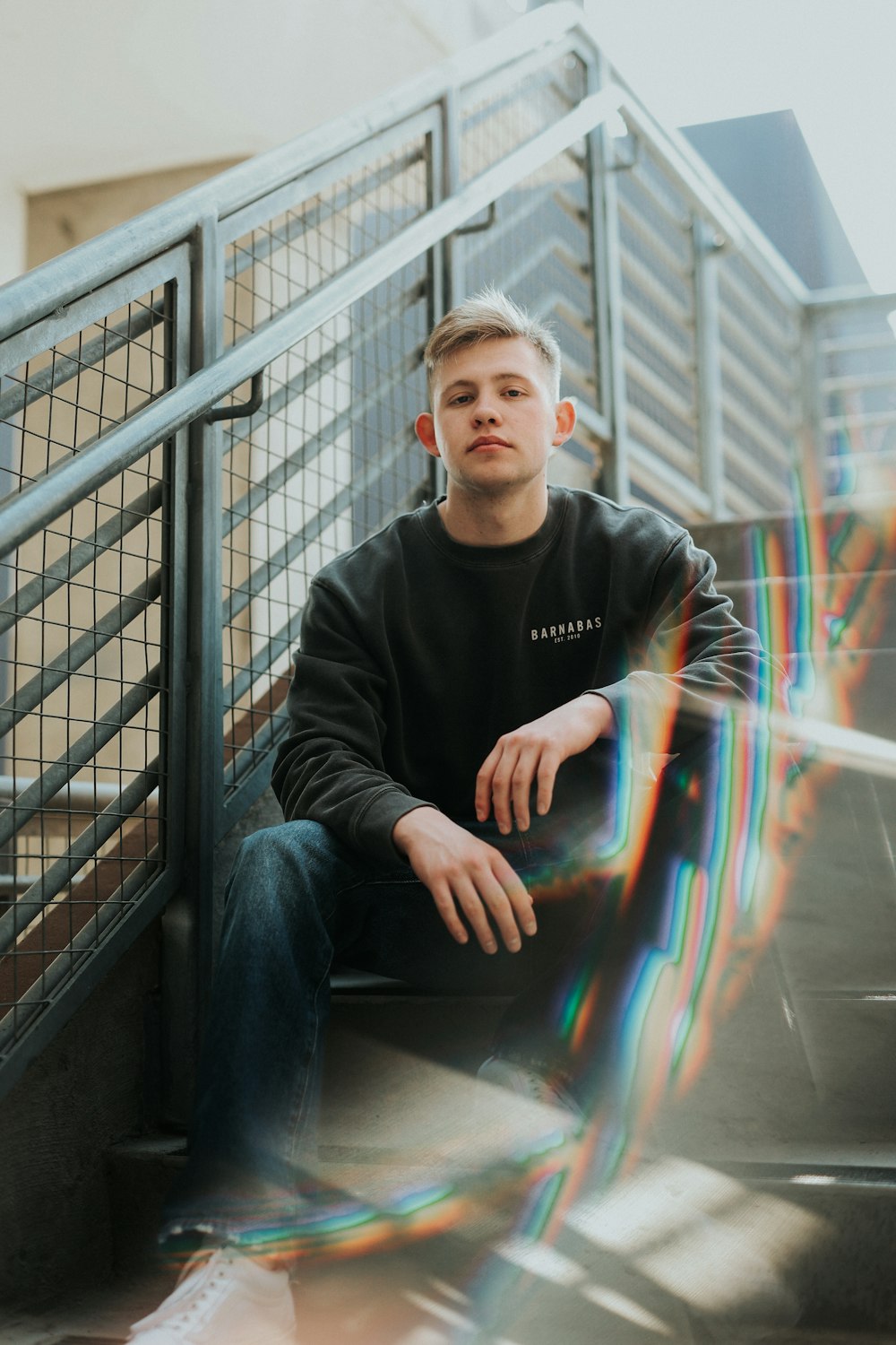 a young man sitting on the steps of a building