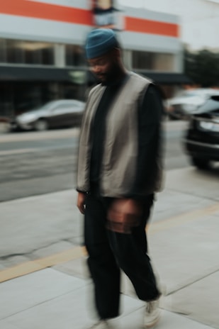 a man walking down a sidewalk next to a street
