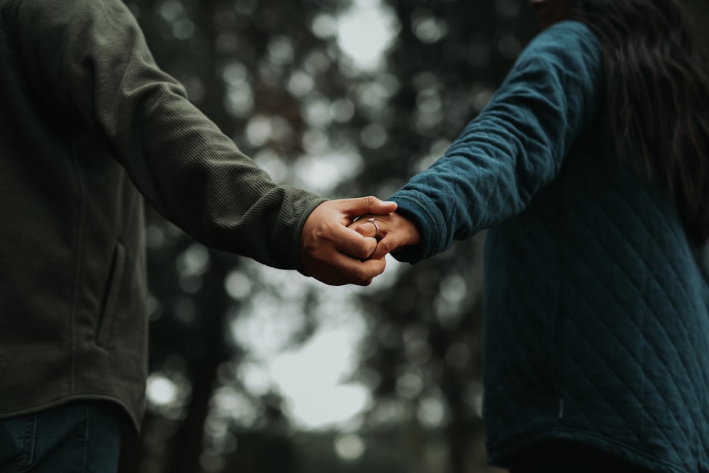 a close up of two people holding hands