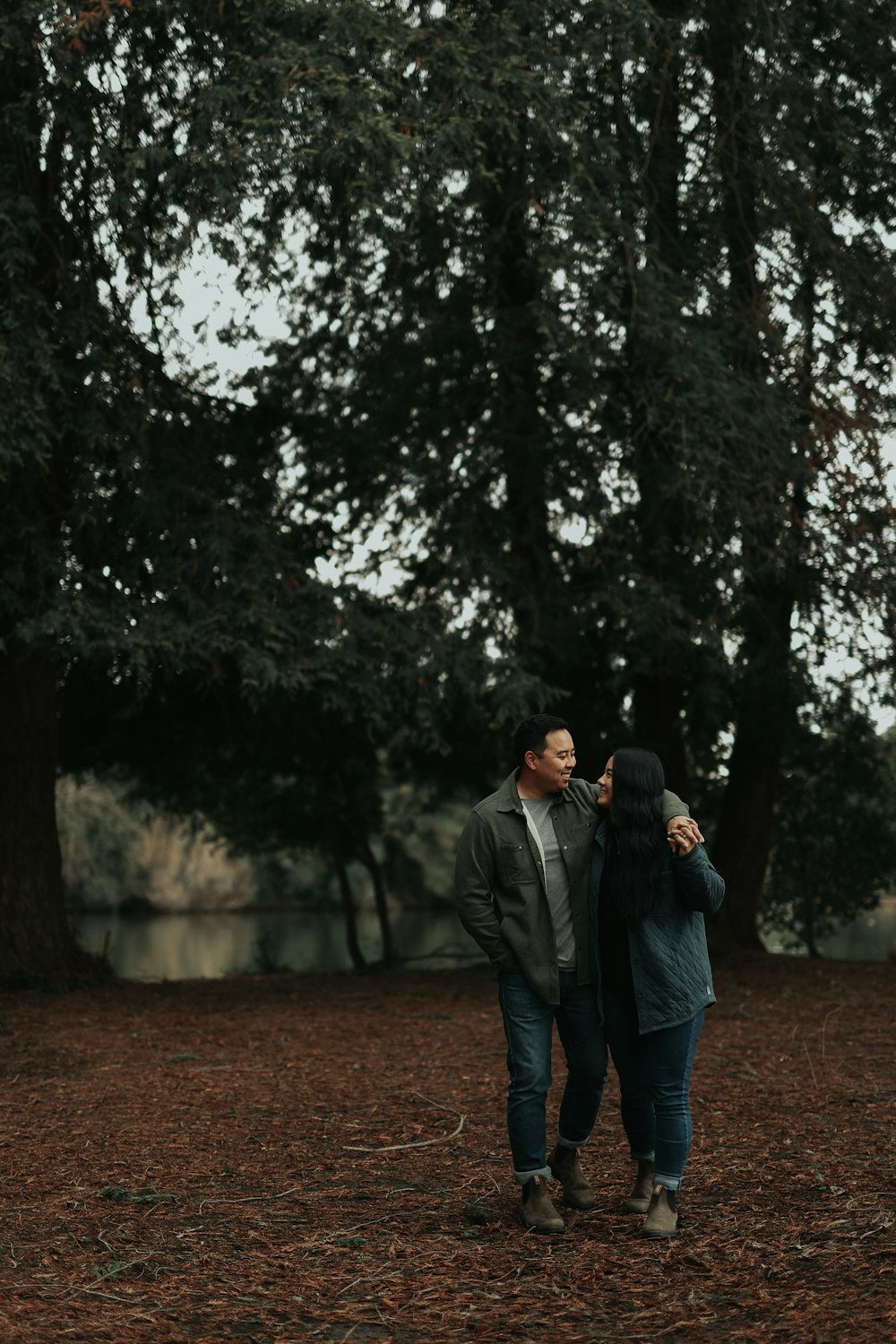 a man and a woman walking through a forest