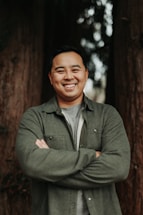 A friendly forestry worker talking on the phone in a green forest setting.