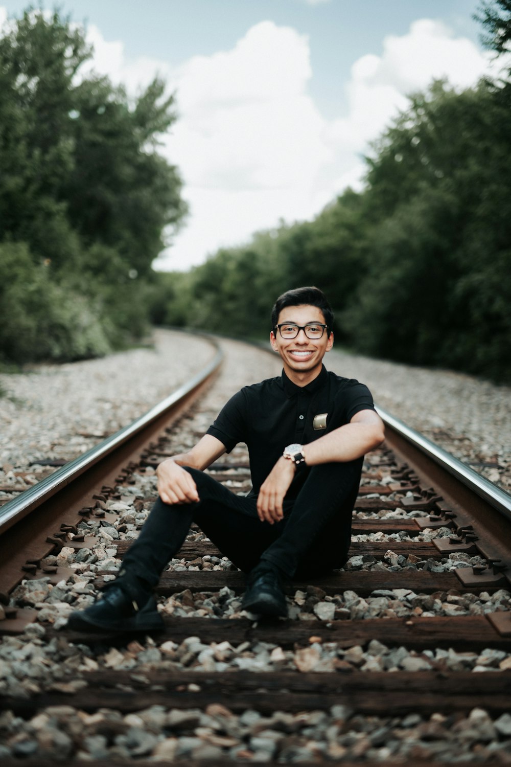Ein Mann sitzt auf einem Bahngleis