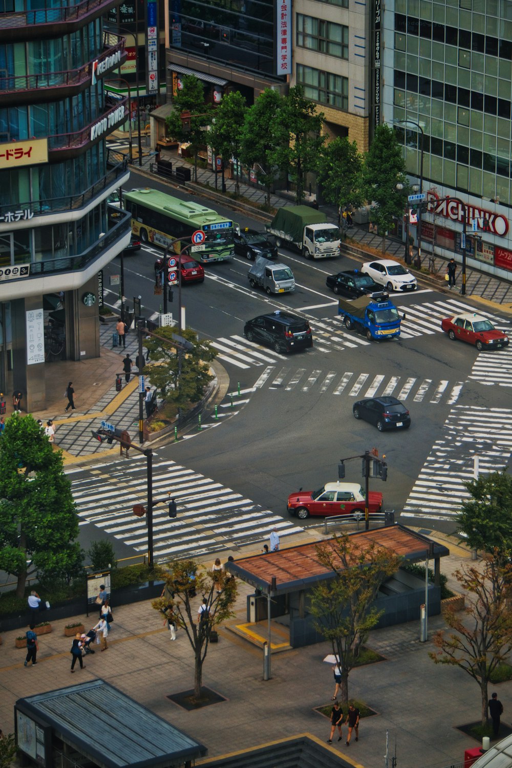 a busy city intersection with cars and pedestrians