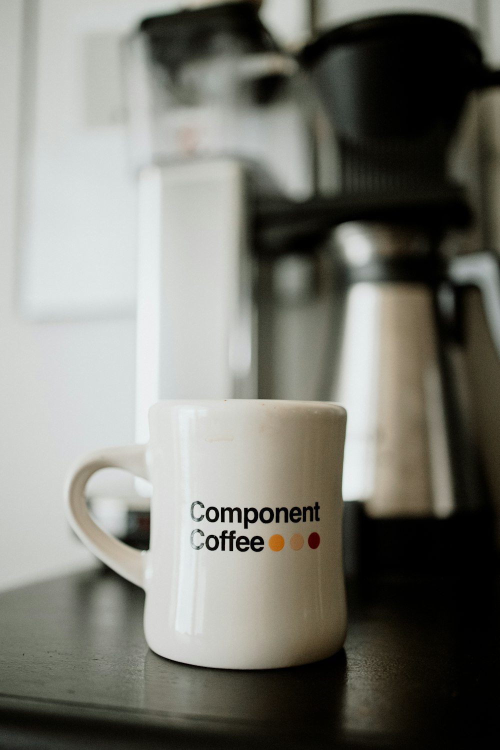 a coffee cup sitting on a table next to a coffee maker