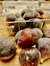 Close-up of ripe figs and dates resting on traditional Persian pottery.