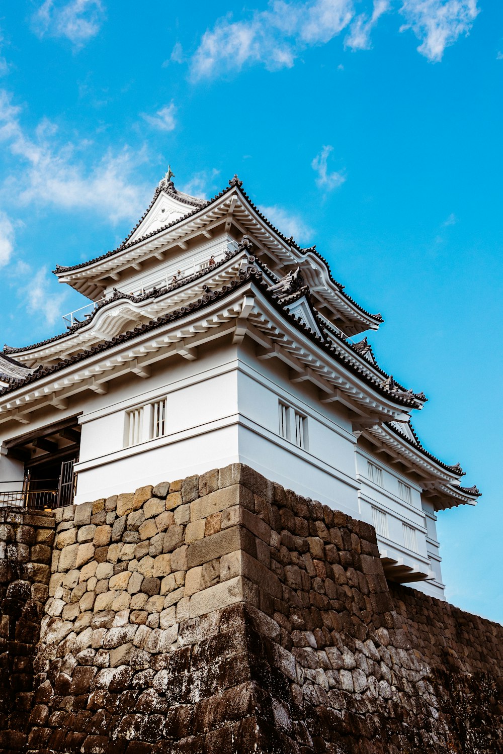 a tall white building sitting on top of a stone wall