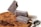 Three chocolate popsicles are arranged on a wooden platter. One popsicle has a bite taken out of it and is leaning against another. Chocolate shavings and pieces of chocolate are scattered on the platter, and a spoon is placed beside them.