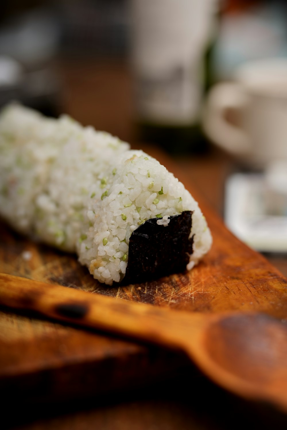 a piece of sushi sitting on top of a wooden cutting board