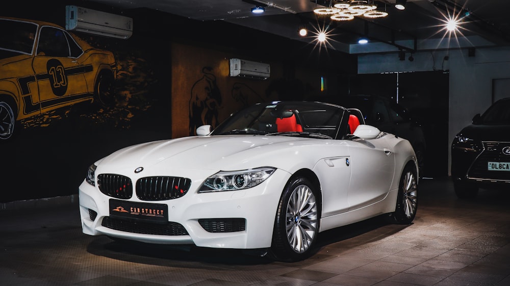 a white sports car parked in a showroom