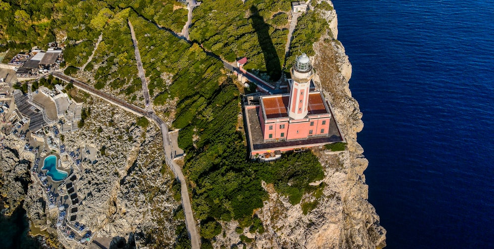 an aerial view of a lighthouse on a cliff next to the ocean