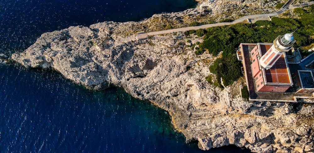 an aerial view of a building on a cliff next to the ocean