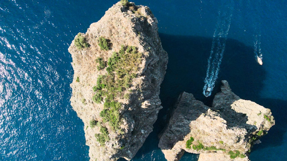 an aerial view of two rocks in the ocean