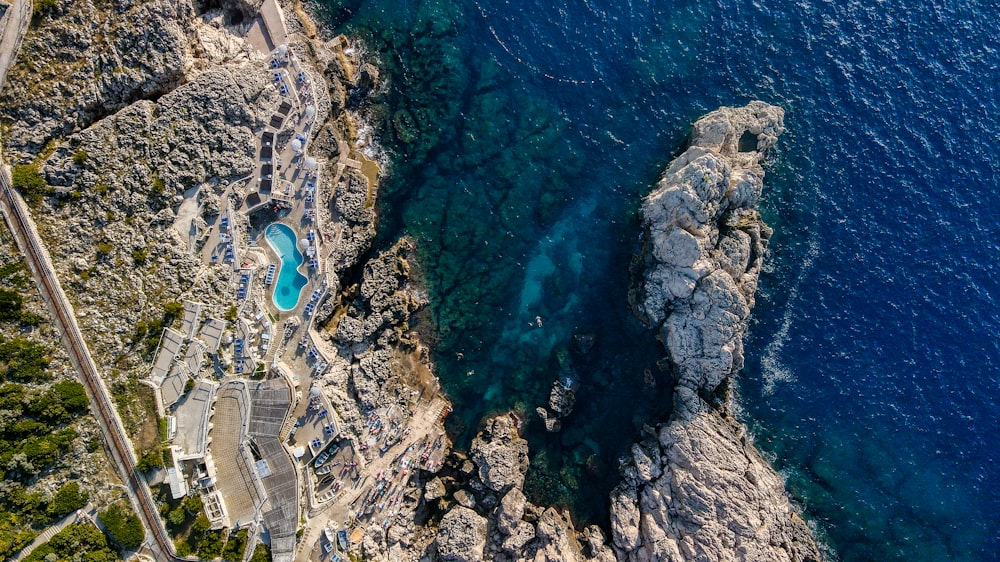 an aerial view of a rocky coastline with a pool