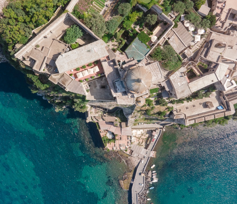 an aerial view of a building next to a body of water