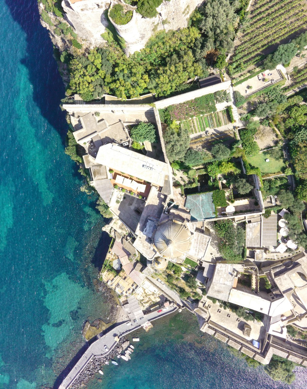 an aerial view of a building next to a body of water