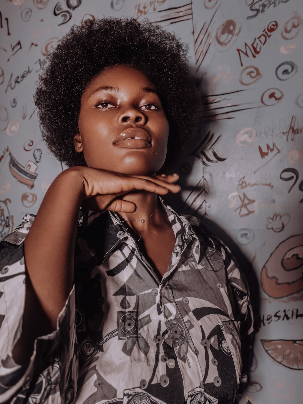 a woman with an afro standing in front of a wall