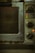 An old, well-used oven with dials and settings for different cooking temperatures and modes. The oven's metal exterior appears worn and dirty, likely from frequent use over time. There is a small red light indicating that part of the appliance is on.