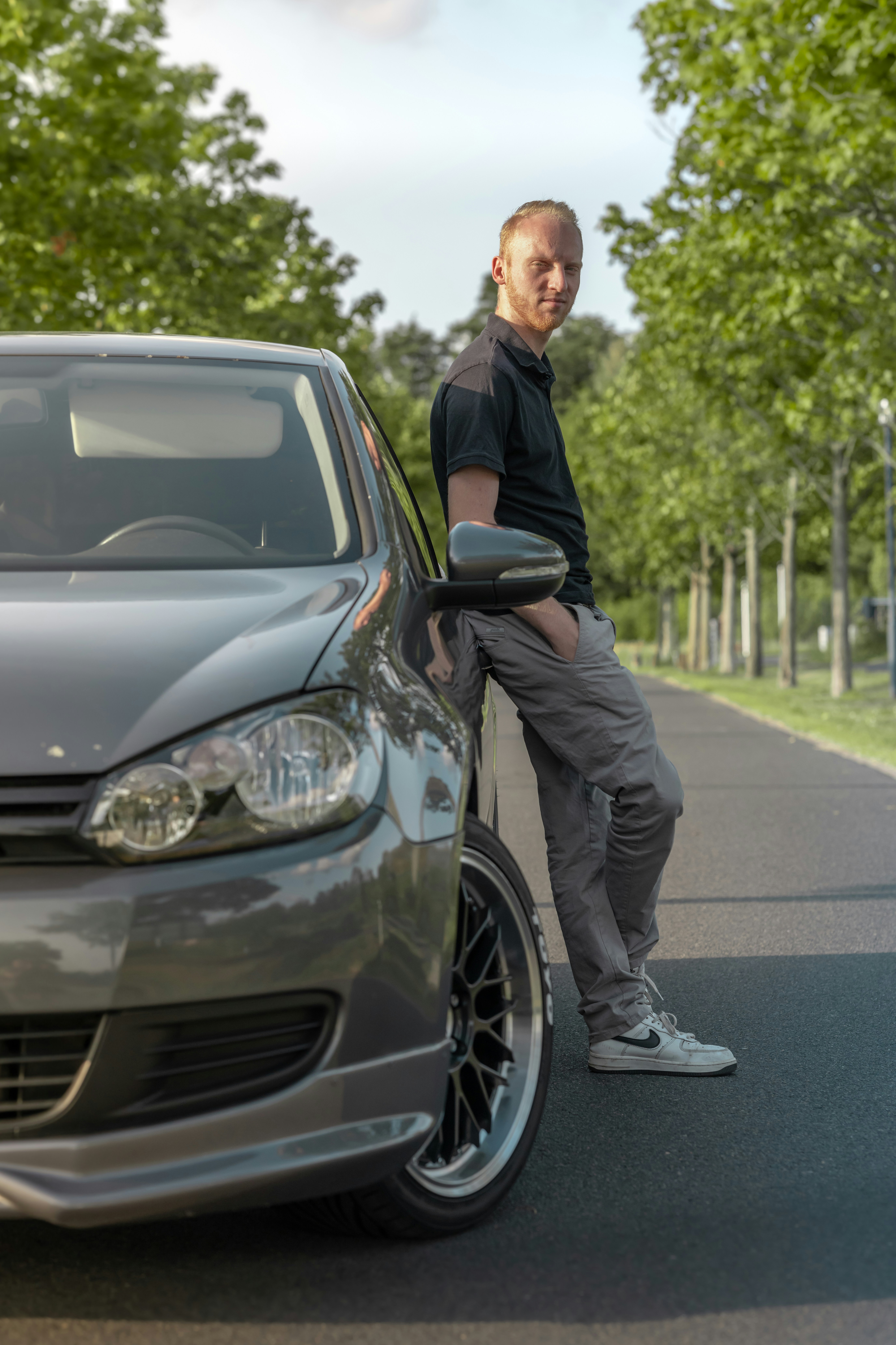 a man leaning on the hood of a car